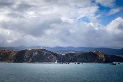 Scenic view of sea and mountains against sky