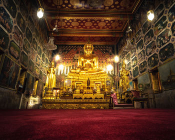 Statue in illuminated temple outside building