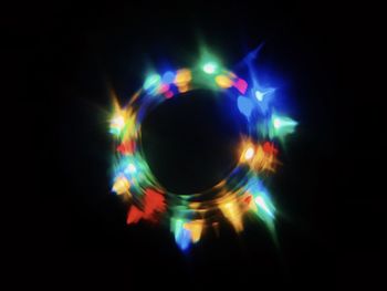 Close-up of illuminated lighting equipment against black background