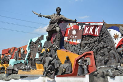 Low angle view of statues against sky