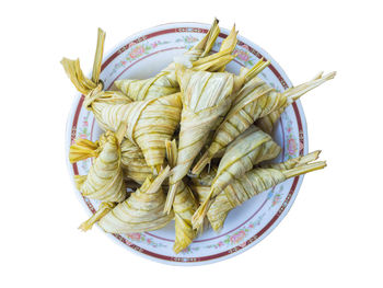 High angle view of vegetables in plate against white background