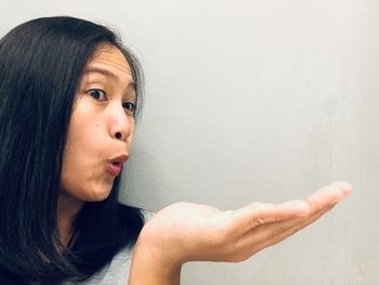 Portrait of young woman against wall