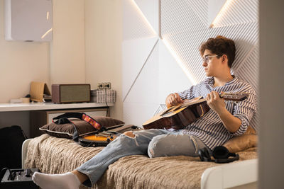 Young woman using laptop while sitting on sofa at home