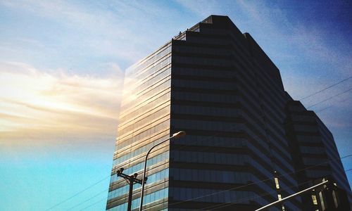 Low angle view of modern building against cloudy sky