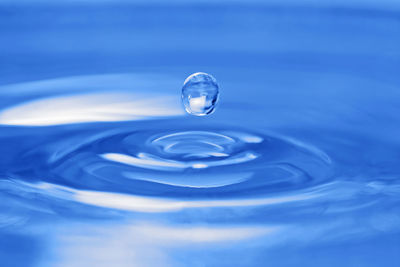 Close-up of water drop against blue background