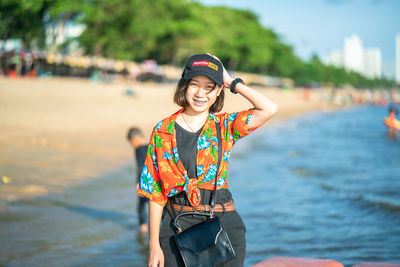 Portrait of smiling young woman standing in water