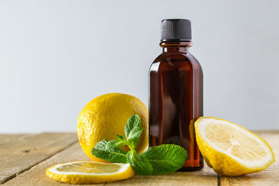 Aromatic oil with lemon and mint on a wooden background. product for relaxation and spa therapy.