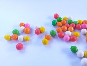 High angle view of multi colored candies against white background