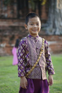 Portrait of smiling girl standing on field