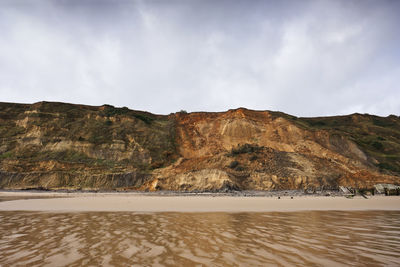 Scenic view of land and mountains against sky