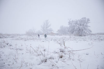 Scenic view of snow covered field against sky