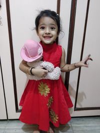 Portrait of smiling girl holding red umbrella