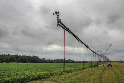 View of farm against cloudy sky