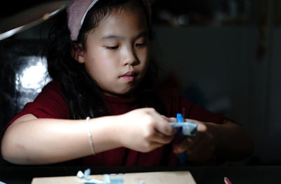 Portrait of girl craft  through desk lamp