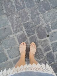 Low section of woman standing on footpath