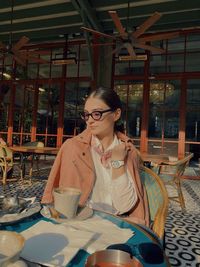 Woman sitting on table at restaurant