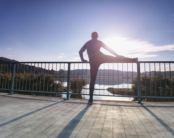 Rear view of man standing on footpath against sky