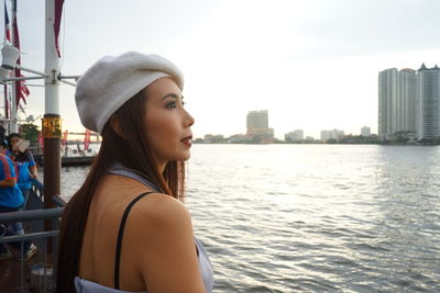 Woman looking at river in city