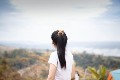 Rear view of woman standing against sky