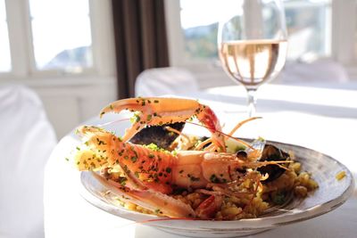 Scampi served with wineglass on table at restaurant