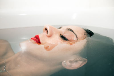 Midsection of woman with chocolate face in bathtub