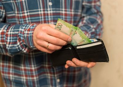 Midsection of man removing paper currencies from wallet