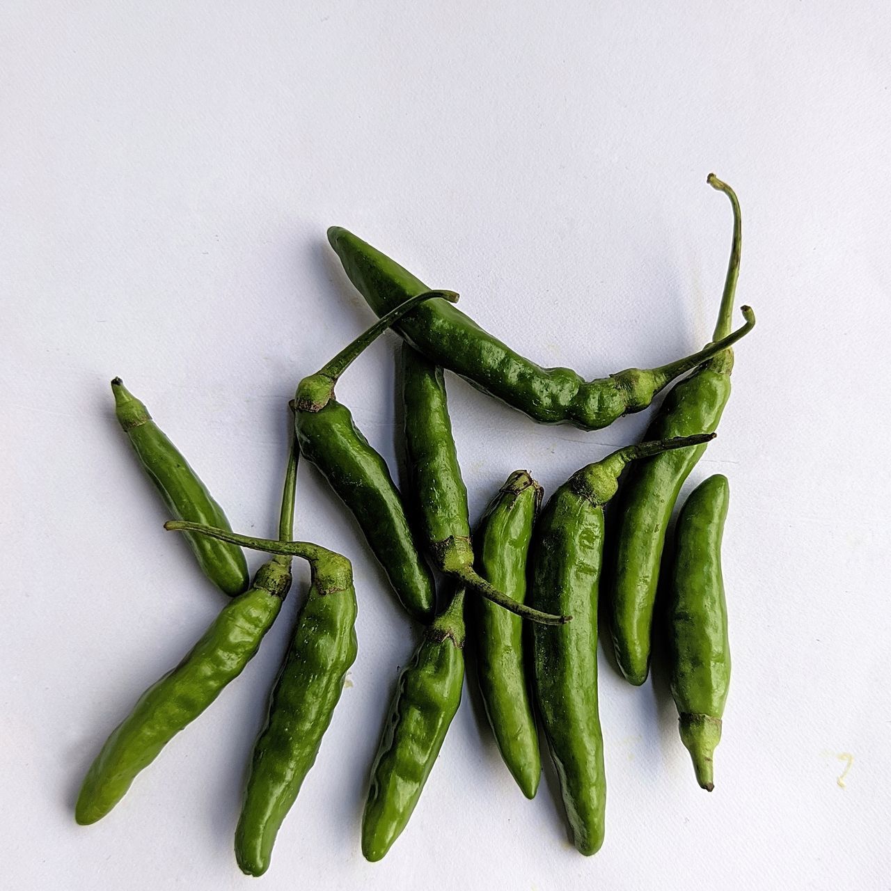 HIGH ANGLE VIEW OF CHILI PEPPERS ON WHITE BACKGROUND