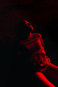 Rear view of a woman sitting in darkroom