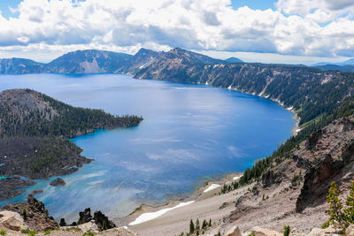 Scenic view of sea and mountains against sky