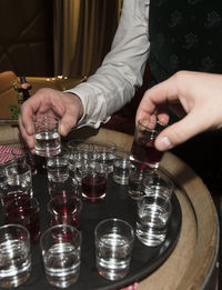 Midsection of man drinking glass on table