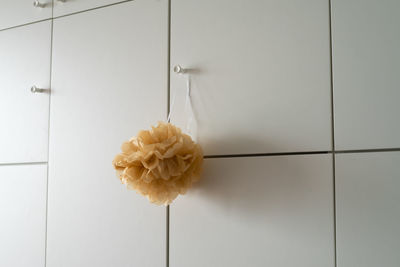 Handmade brown paper pom pom hanging in a room cabinet door. minimalism concept if interior design.