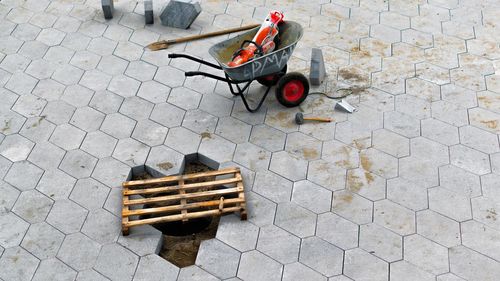 High angle view of wheelbarrow and work tools on street