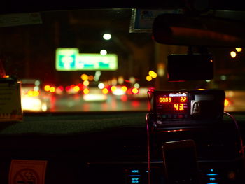 Cars on illuminated street in city at night