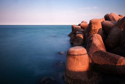 Close-up of rocks on beach against sky during sunset