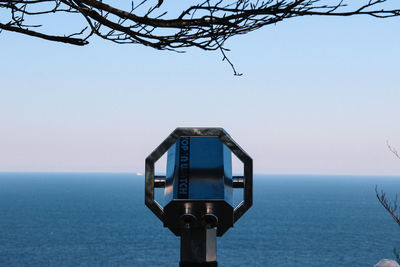 Close-up of camera against sea against clear sky