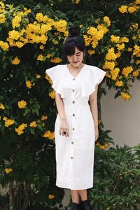 Full length of woman standing on yellow flowering plants