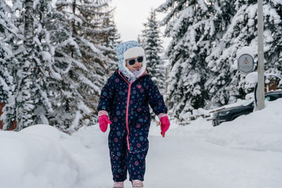 Little girl of 4 yo is playing in the snow