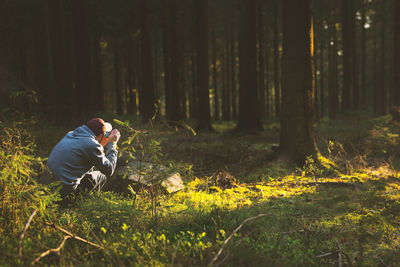 Man photographing in forest