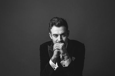 Portrait of young man against black background