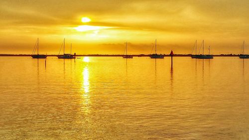 Sailboat in sea at sunset