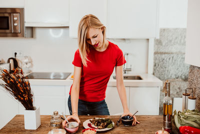 Young woman standing by food at home