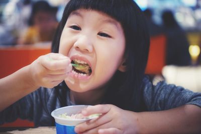 Portrait of boy eating ice cream in restaurant