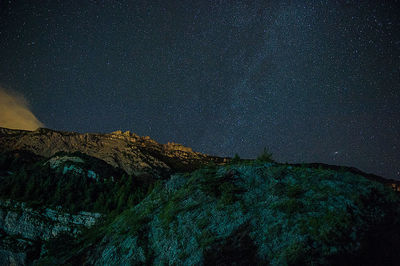 Low angle view of mountains against star field