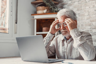 Woman using laptop while sitting on table