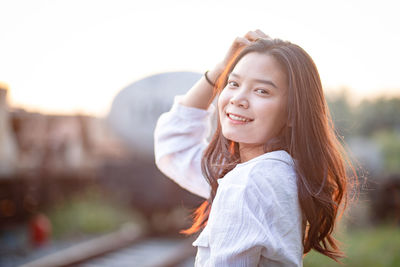 Portrait of smiling girl standing against sky