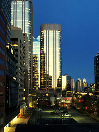 Modern buildings in city against sky at dusk