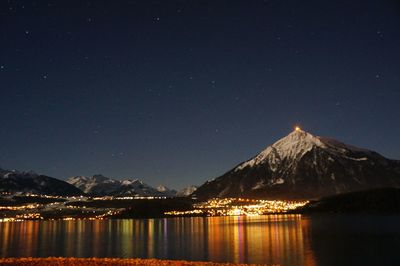 River with illuminated structures in distance