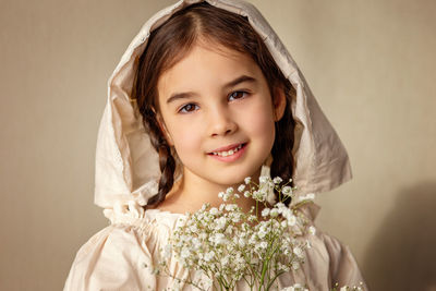 Portrait of a beautiful girl in a white retro cap and a bouquet of white gypsophila flowers