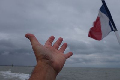 Cropped hand by french flag at sea9