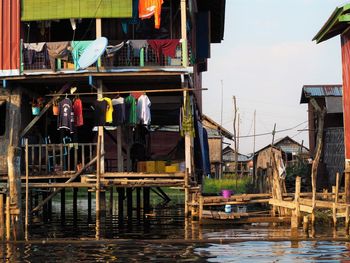 Wooden post in lake against buildings